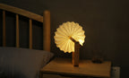 Gingko Design – Lámpara Smart Origami - Bambú Natural, lámpara de noche encendida sobre una mesita de noche de madera