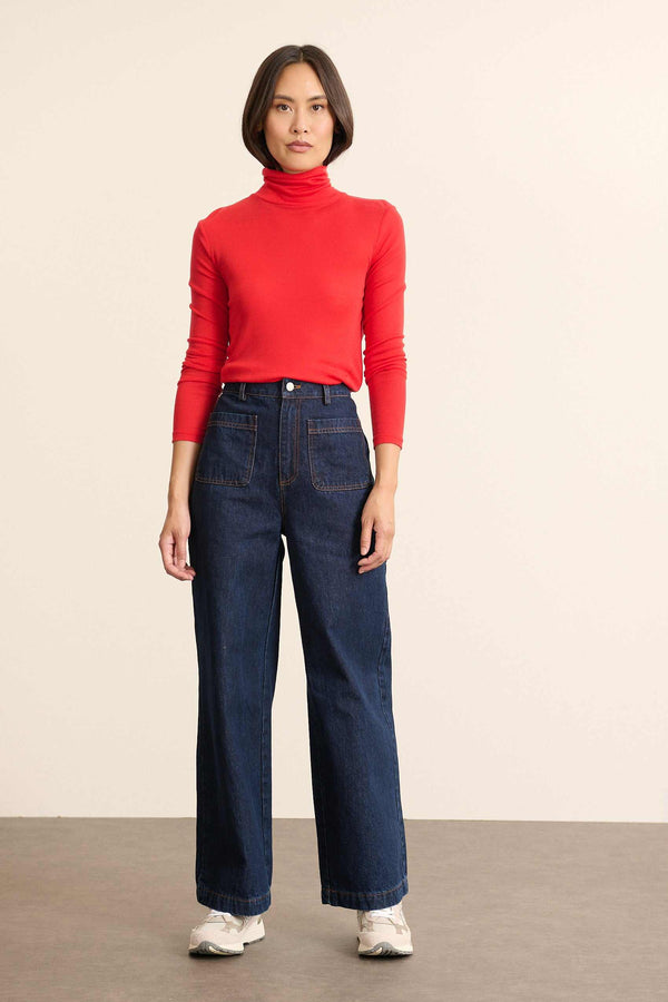 Mannequin femme de face portant un sous-pull rouge à col montant, coupe ajustée et manches longues en maille fine. 