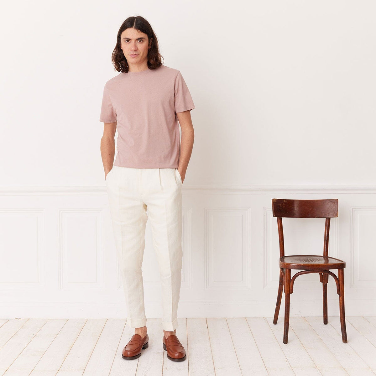 Hast – T-shirt i ekologisk bomull, ljusrosa, manlig modell i rosa t-shirt och vita byxor, framifrån