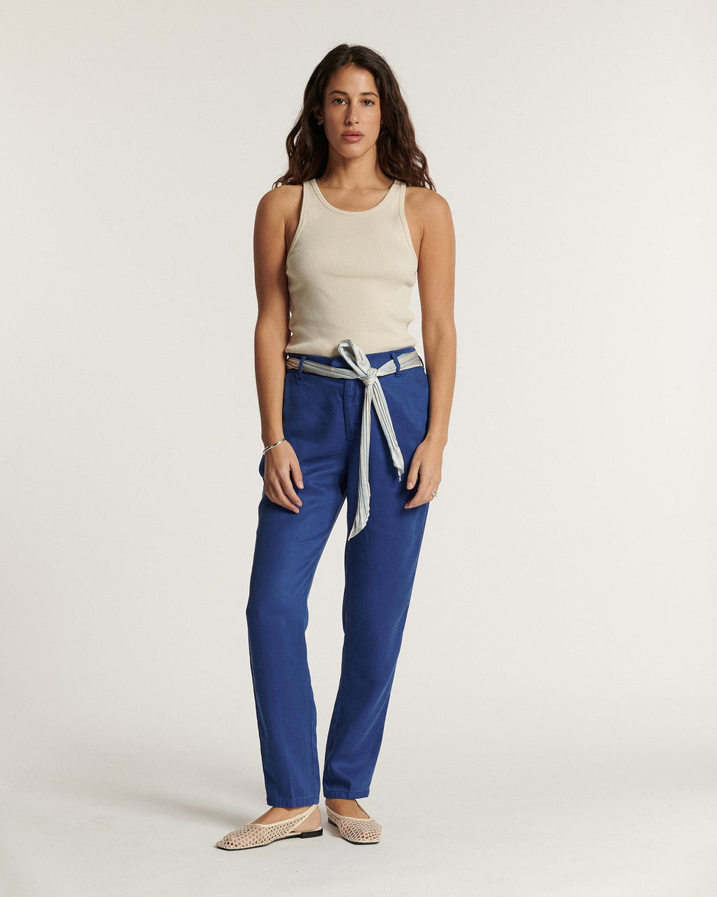Navy blue tencel pants, straight and fitted cut, fluid and soft material, integrated belt tied at the waist for a feminine and comfortable style.