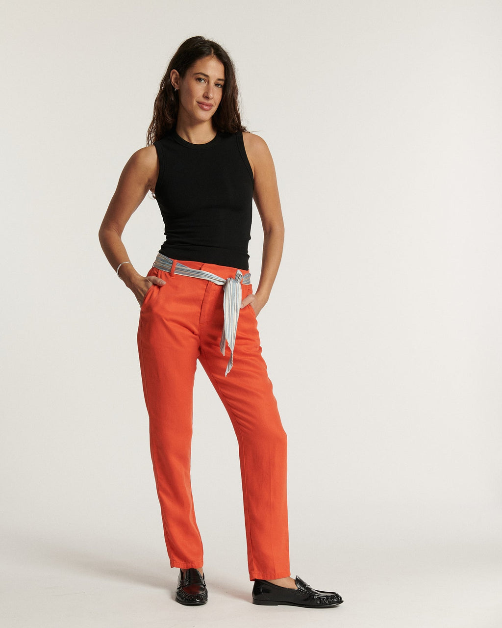 Pantalon en tissu tencel orange doux avec coupe droite adaptée à toutes les morphologies, ceinture rayée assortie, style féminin et confortable.