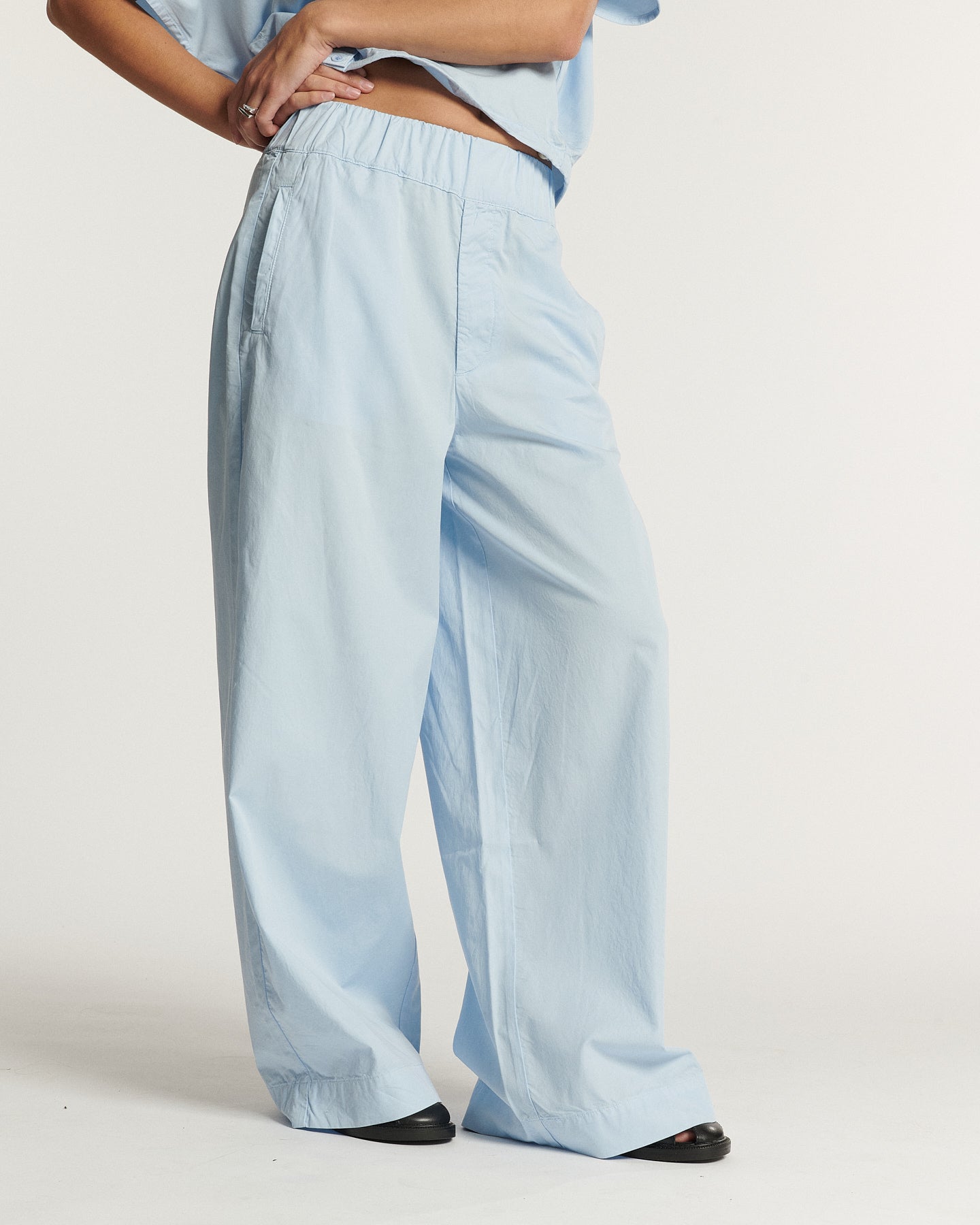 Pantalon large pour femme en popeline légère bleu clair, coupe fluide avec taille élastique pour un confort optimal et un style décontracté.