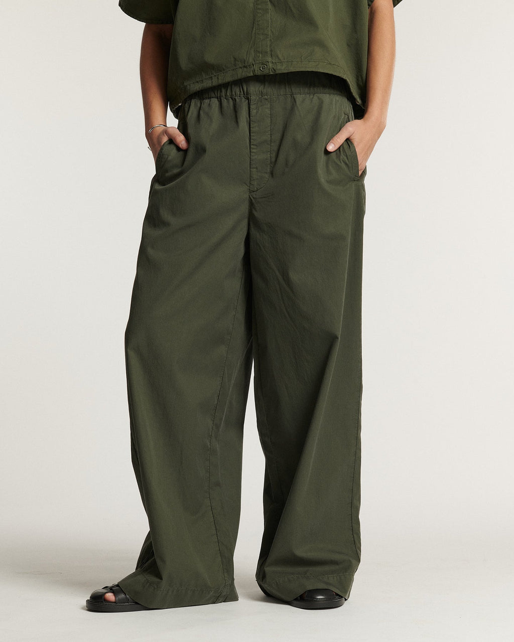 Pantalon femme ample en popeline kaki, matière légère et fluide, coupe large et décontractée avec taille élastique pour un confort optimal.