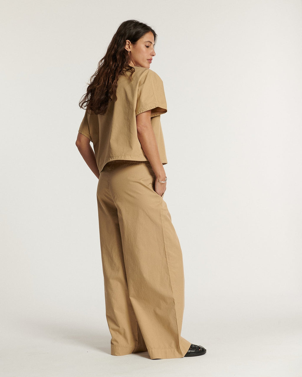 Pantalon large en popeline couleur praline, coupe ample et fluide, en coton léger idéal pour la saison estivale, offrant un style décontracté et élégant.