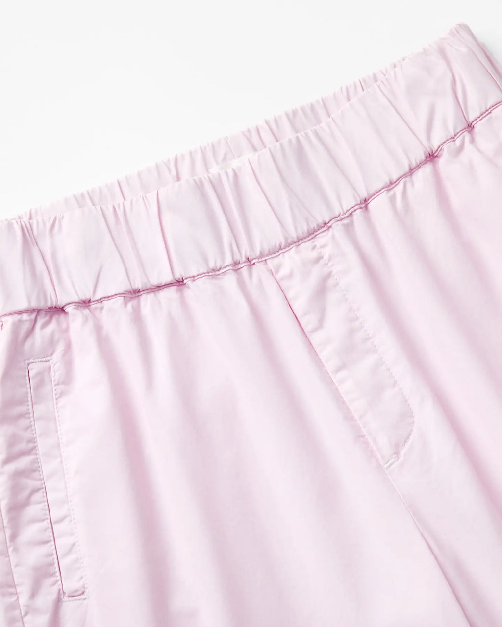 Light pink poplin pants with elastic waist, straight cut and visible stitching details for comfort and a casual look for women.