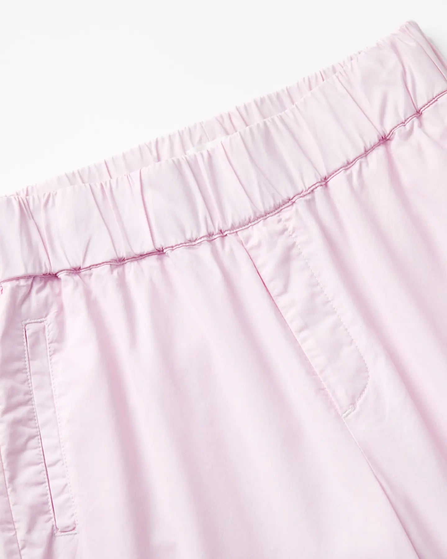 Light pink poplin pants with elastic waist, straight cut and visible stitching details for comfort and a casual look for women.