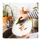 Eponge lavable jaune nettoyant une assiette