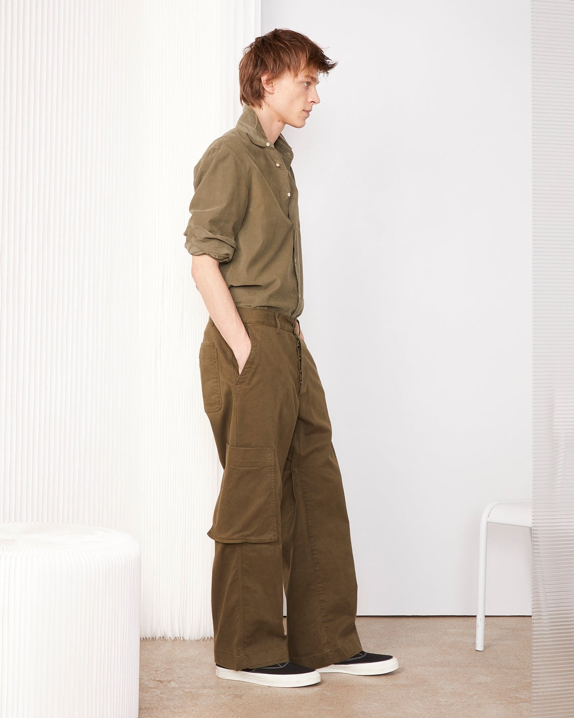Officine Générale – Chino Naim - Olive Nuit - Homme, mannequin homme de profil portant une chemise et un pantalon kaki