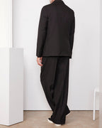 Officine Générale – Veste Leon - Noir - Homme, homme de dos portant un costume noir ample