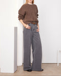 Officine Générale – Pull Mimy Col Rond - Café Glacé/Gris Moyen - Femme, mannequin femme blonde portant un pull marron et un jean gris
