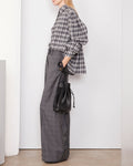 Officine Générale – Chemise Mahault - Gris Moyen/Gris Foncé - Femme, mannequin de profil portant une chemise à carreaux et un pantalon gris
