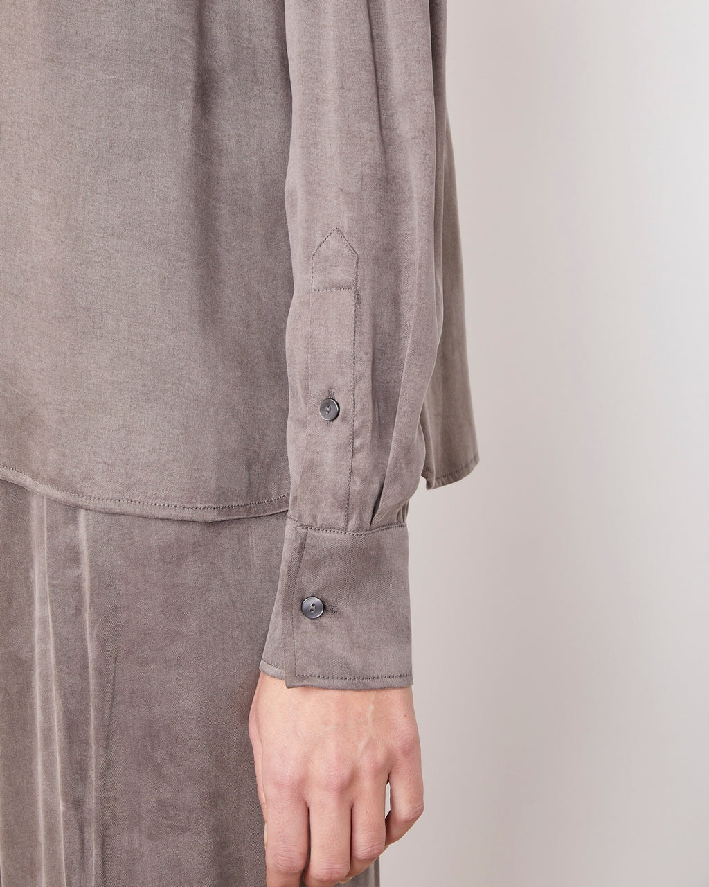 Officine Générale – Top Rimy - Anthracite - Femme, mannequin portant une chemise grise en soie, gros plan sur le poignet