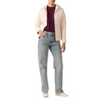 Jott – Piumino con cappuccio donna Jott CLOE, modella che indossa un piumino rosa chiaro, una t-shirt bordeaux e jeans azzurri