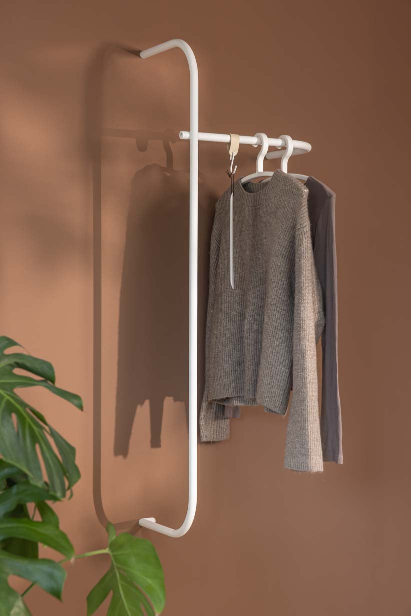 Armario moderno TAMINA con metallstangen minimalista y aufgehängten kleidungsstücken.