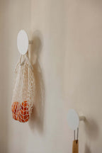 Wandhaken LOU mit Netzbeutel und Orangen, minimalistisches Design für moderne Aufbewahrung.