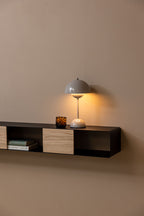 Hängekonsole SION mit Tischlampe und Dekorationsgegenständen an einer Wand.