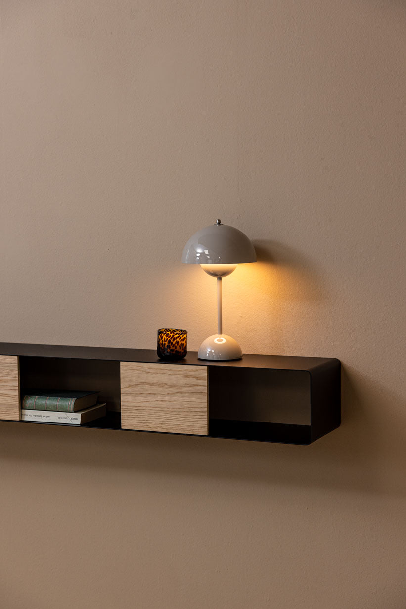 Hängekonsole SION mit Tischlampe und Dekorationsgegenständen an einer Wand.