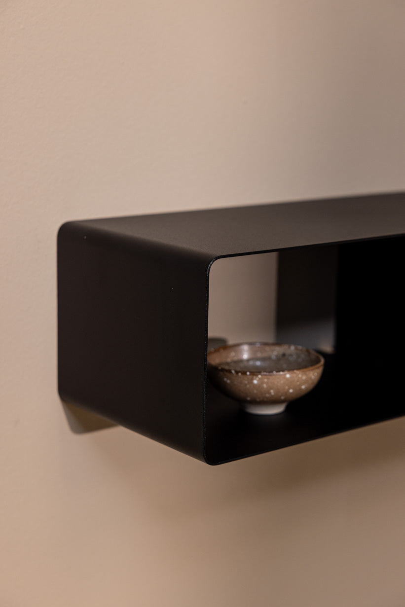 Hängekonsole SION in schwarz mit dekorativen Schalen auf der Ablage.