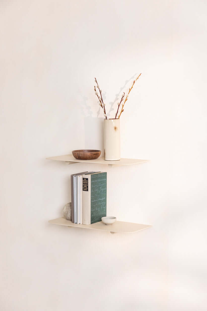 Wandregal mit Deko-Vasen und Büchern an einer hellen Wand, modern Design für stylish Innenräume.
