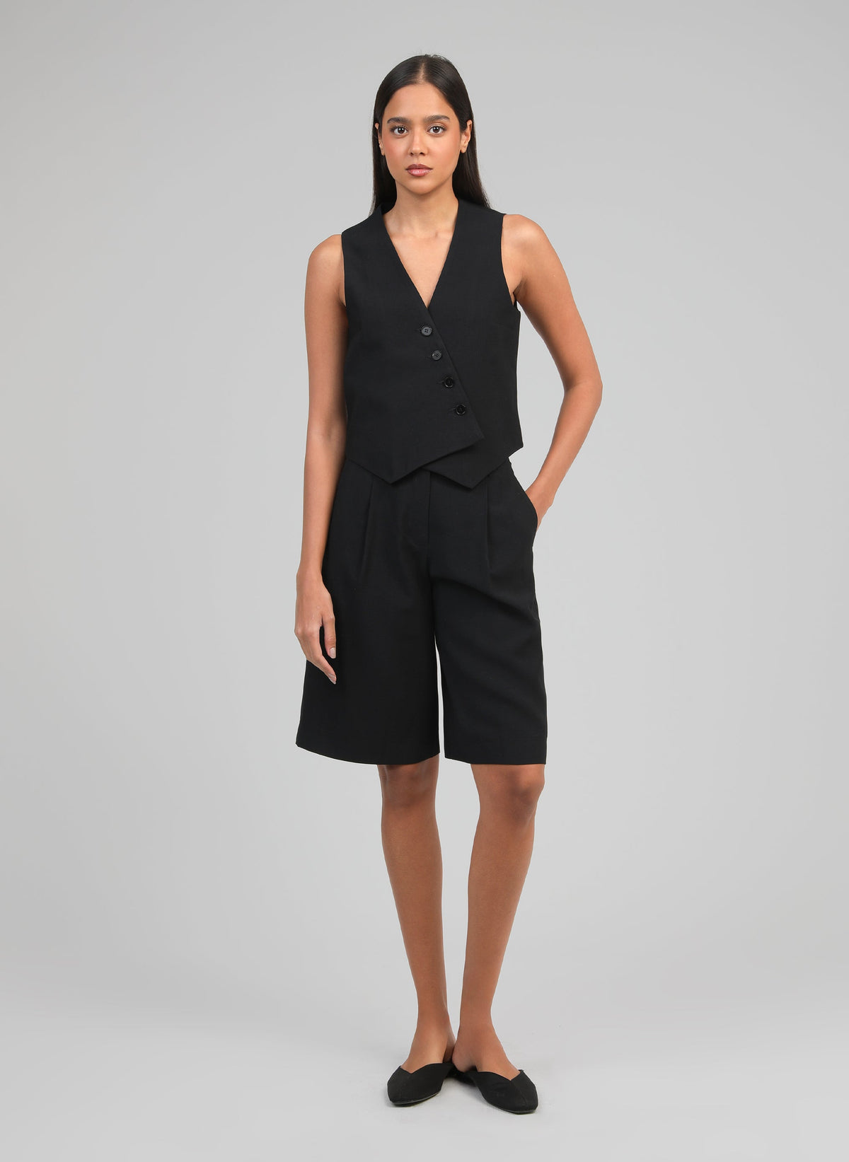 An'ge – Väst Zakina Noir, modell i ett svart set med väst och bermudashorts, framifrån