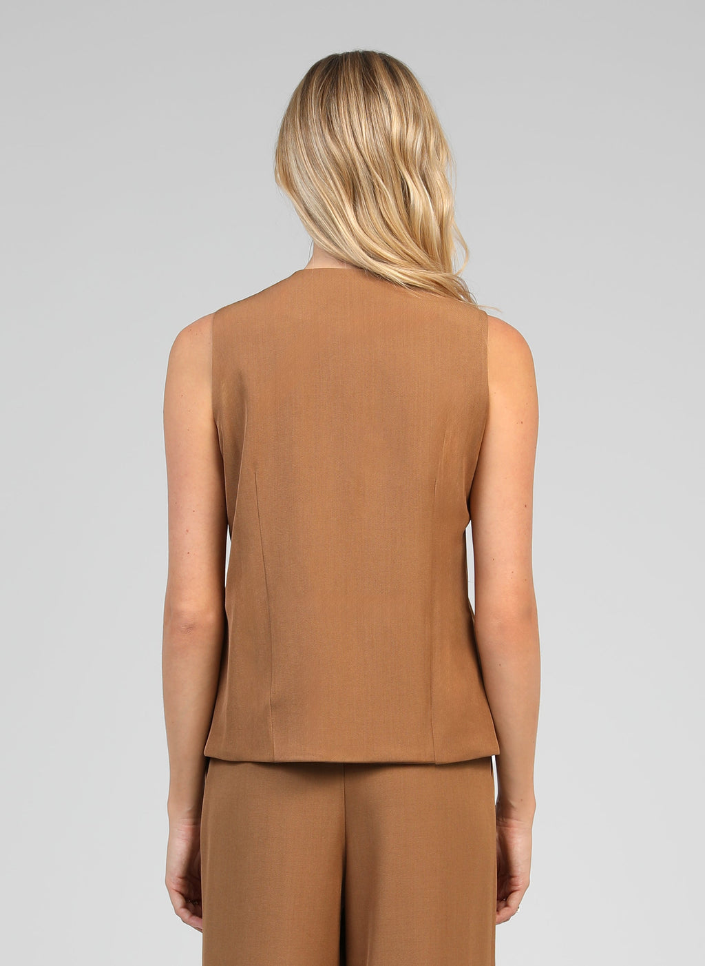 An'ge – Kostuumgilet Zola Camel, model op de rug gezien in een mouwloze bruine top