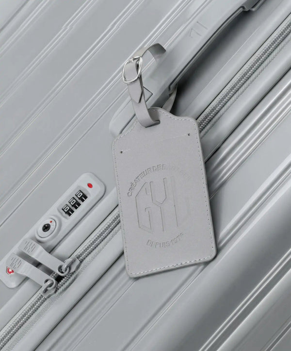 Etiquette a bagages GYL argent accrochee sur valise Intemporelle argent