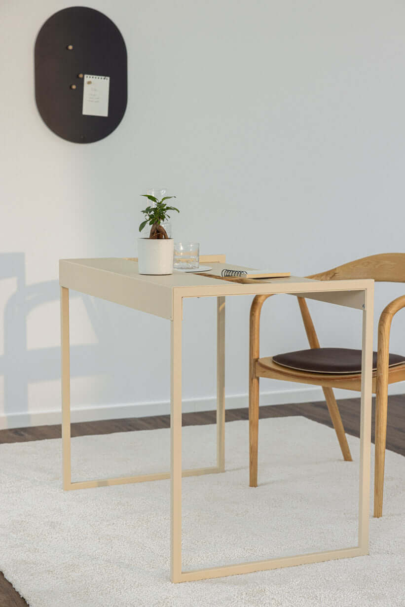 Schreibtisch DONNA in modernem Raum mit Stuhl, Pflanze und Schreibmaterial.