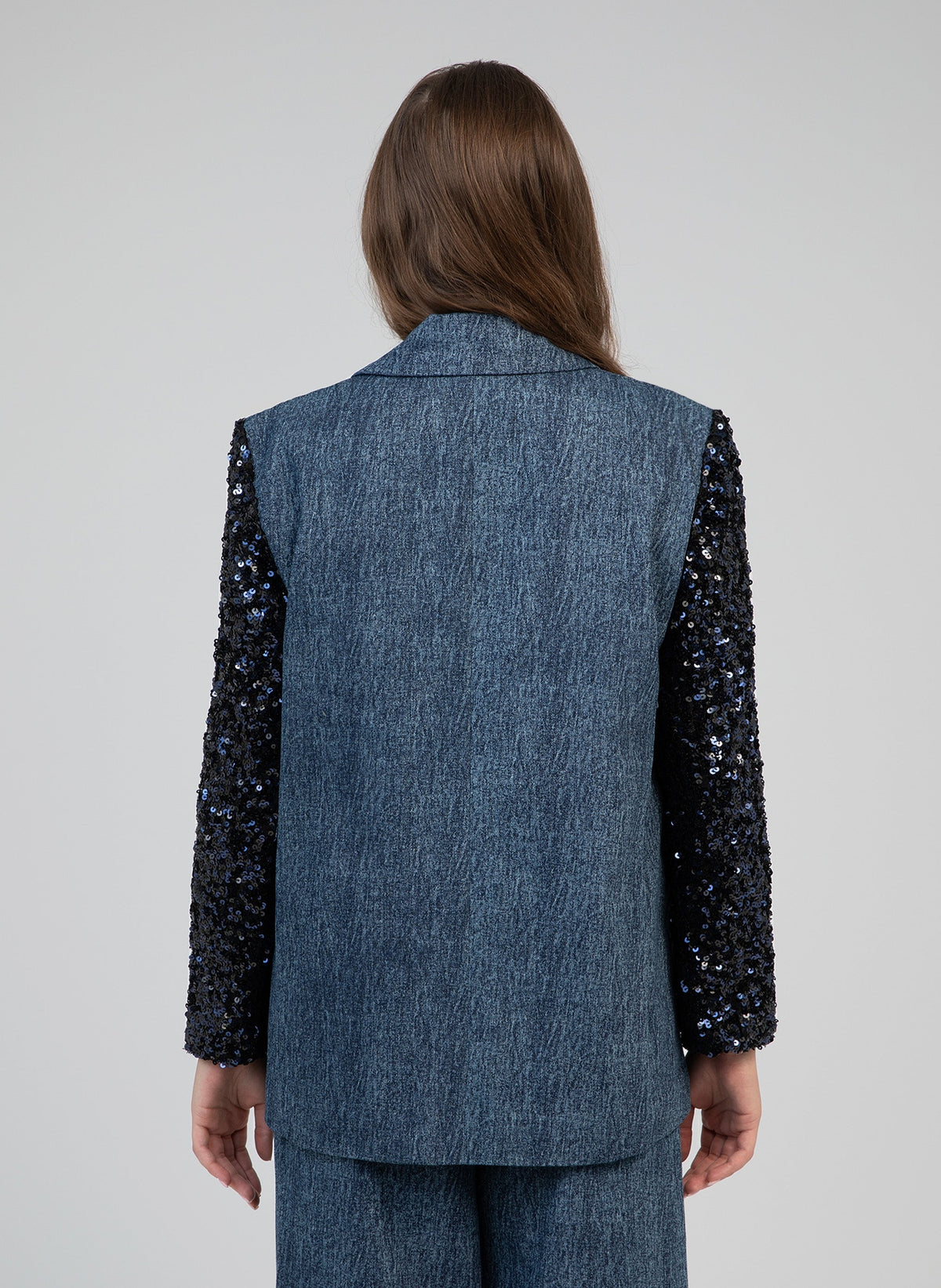 An'ge – Chaqueta Howela Jean, modelo de espaldas con chaqueta vaquera azul con mangas de lentejuelas