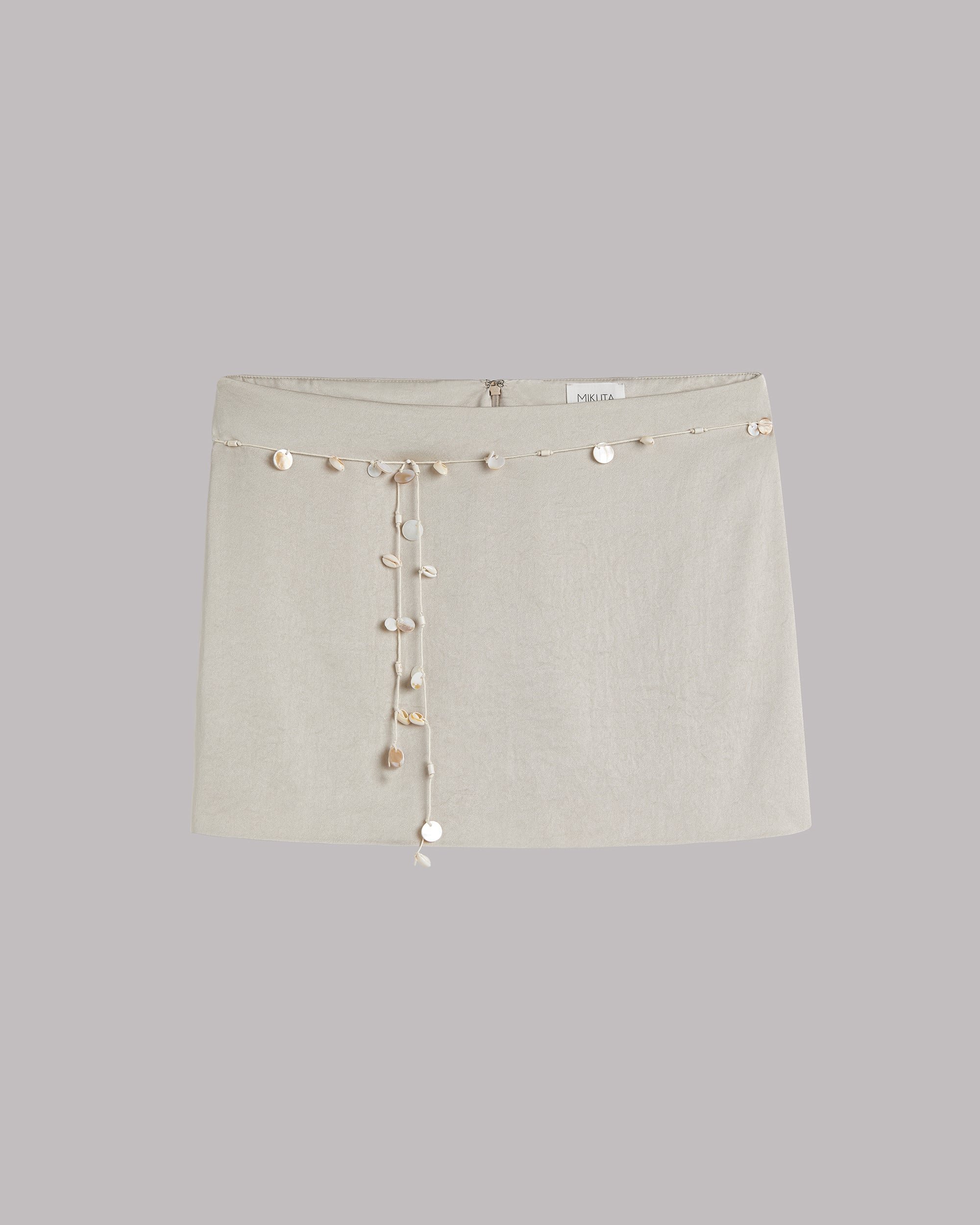 Light mini skirt with decorative shells on a light gray background
