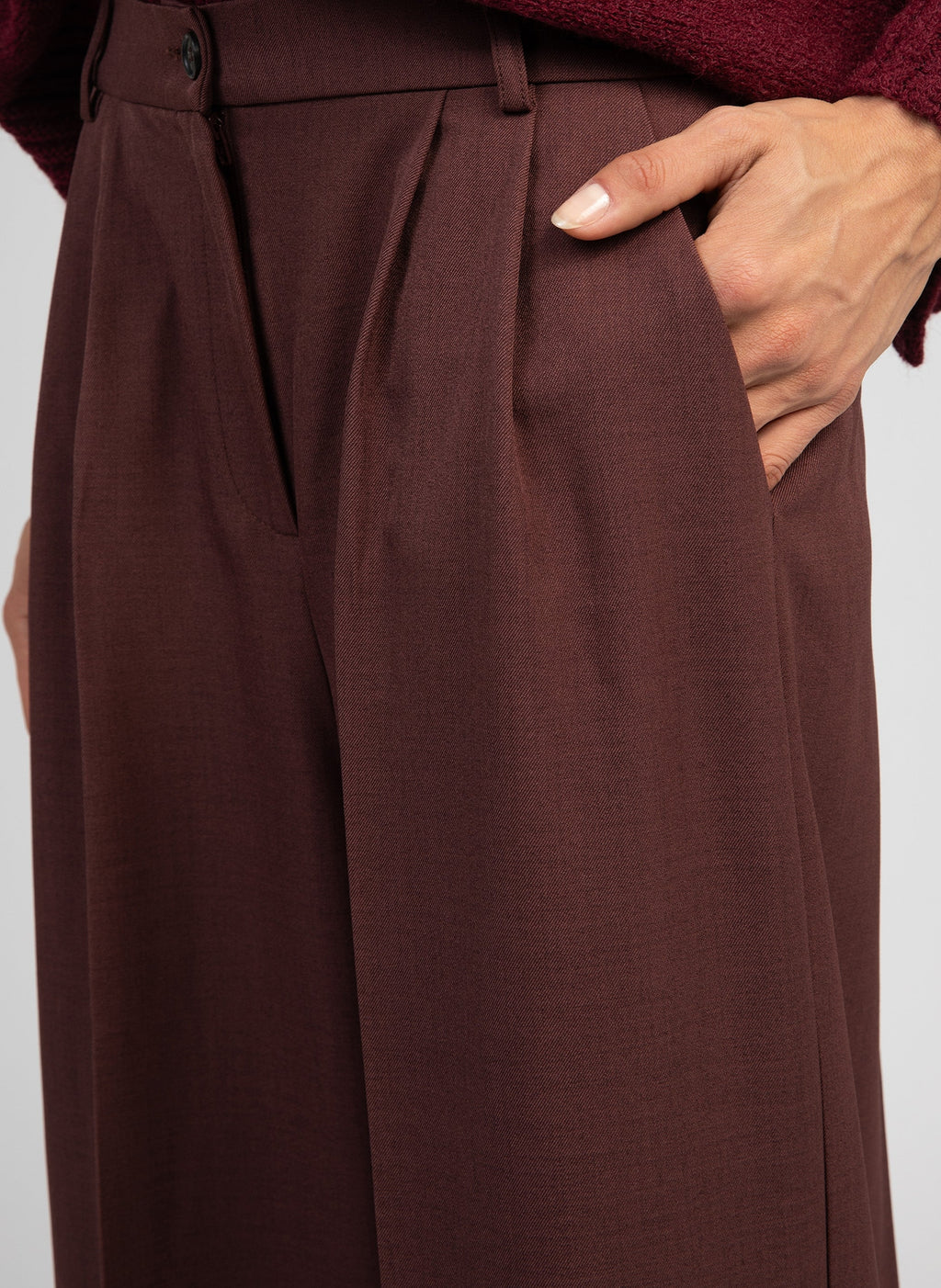 An'ge – Pantaloni Pepina cioccolato, pantaloni marrone scuro indossati da una modella, con la mano in tasca