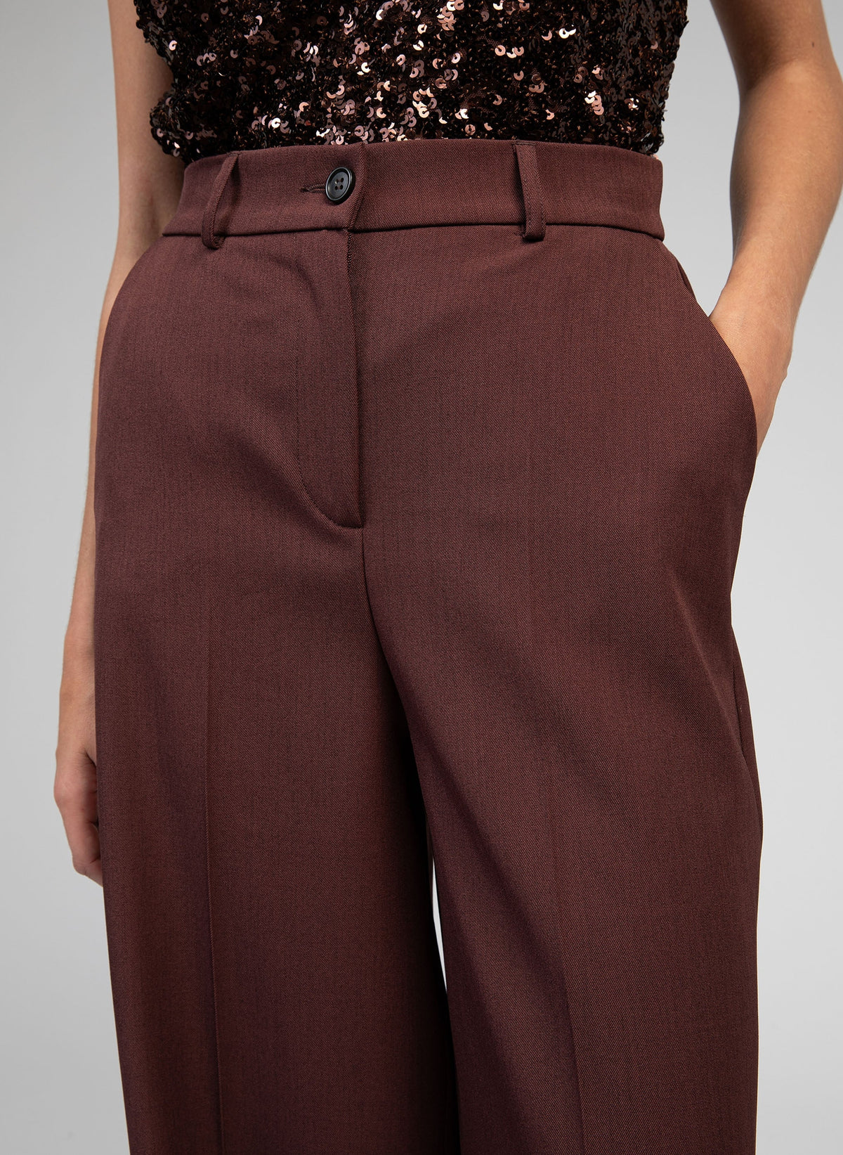 An'ge – Hose Perlina Schokolade, dunkelbraune Hose, von einem Model getragen, Vorderansicht, Bund-Detail
